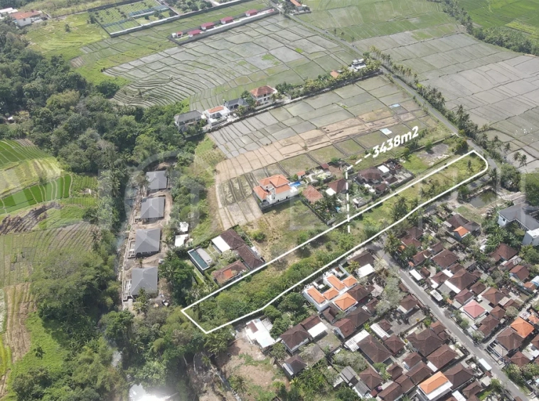 3,438 sqm east-facing riverside leasehold land in Kaba Kaba, Bali, surrounded by protected green-zone rice fields with panoramic river, rice terrace, and mountain views, featuring 4-meter asphalt road access and ideal for villa development.