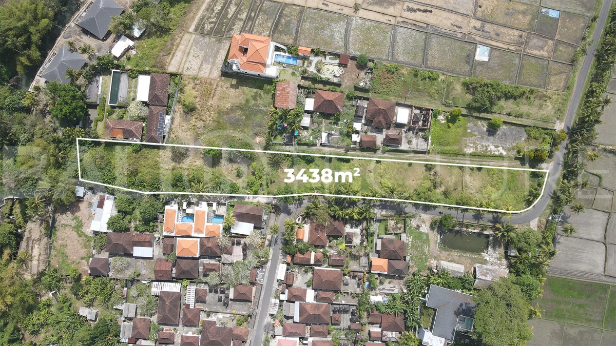 3,438 sqm east-facing riverside leasehold land in Kaba Kaba, Bali, surrounded by protected green-zone rice fields with panoramic river, rice terrace, and mountain views, featuring 4-meter asphalt road access and ideal for villa development.