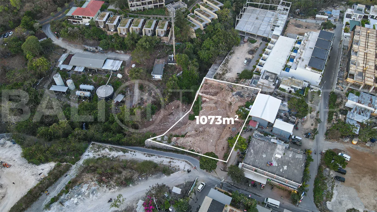 Aerial view of 1,073m² leasehold land for sale near Bingin Beach, Uluwatu, overlooking the ocean with stunning sunset views, surrounded by villas, cafés, restaurants, and coastal developments.