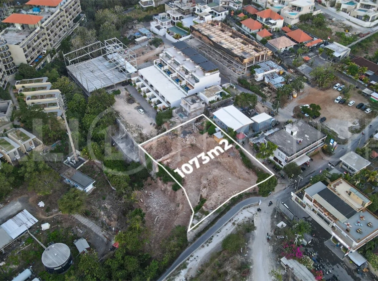 Aerial view of 1,073m² leasehold land for sale near Bingin Beach, Uluwatu, overlooking the ocean with stunning sunset views, surrounded by villas, cafés, restaurants, and coastal developments.
