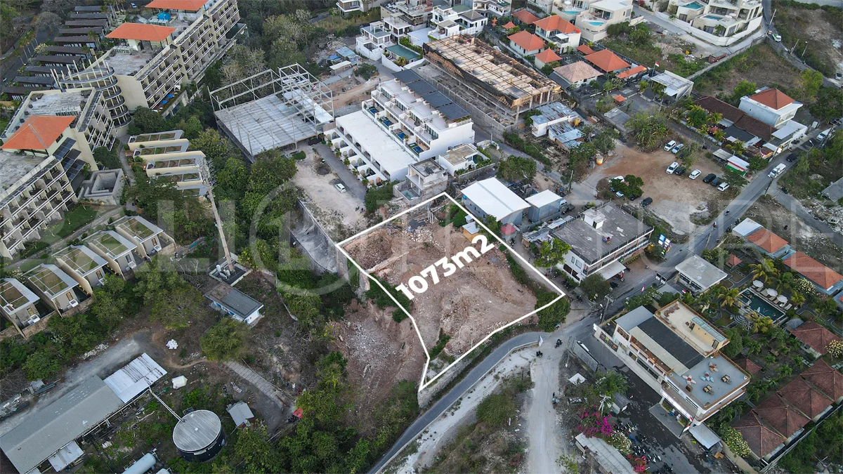 Aerial view of 1,073m² leasehold land for sale near Bingin Beach, Uluwatu, overlooking the ocean with stunning sunset views, surrounded by villas, cafés, restaurants, and coastal developments.