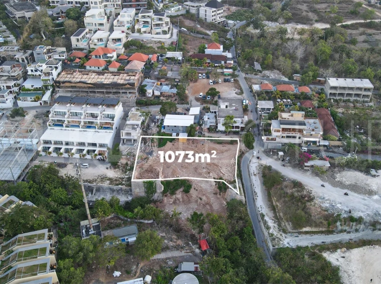 Aerial view of 1,073m² leasehold land for sale near Bingin Beach, Uluwatu, overlooking the ocean with stunning sunset views, surrounded by villas, cafés, restaurants, and coastal developments.