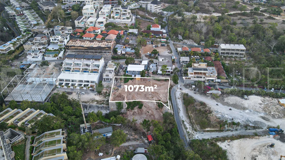 Aerial view of 1,073m² leasehold land for sale near Bingin Beach, Uluwatu, overlooking the ocean with stunning sunset views, surrounded by villas, cafés, restaurants, and coastal developments.