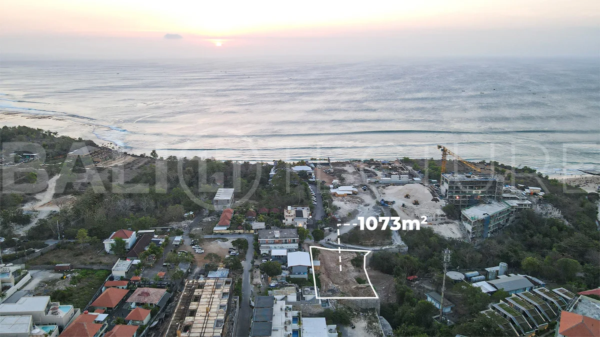 Aerial view of 1,073m² leasehold land for sale near Bingin Beach, Uluwatu, overlooking the ocean with stunning sunset views, surrounded by villas, cafés, restaurants, and coastal developments.