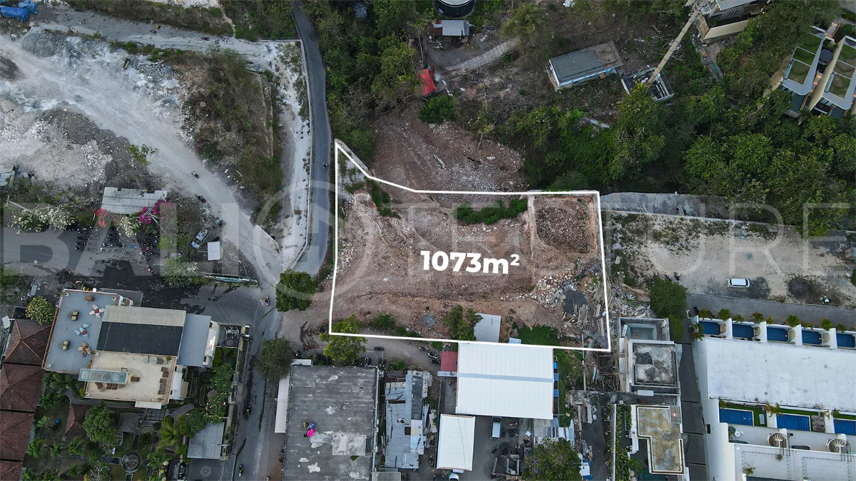 Aerial view of 1,073m² leasehold land for sale near Bingin Beach, Uluwatu, overlooking the ocean with stunning sunset views, surrounded by villas, cafés, restaurants, and coastal developments.