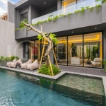 Modern two-storey luxury villa in Ubud featuring a private swimming pool, lush tropical landscaping, floor-to-ceiling glass doors, and a stylish contemporary exterior.