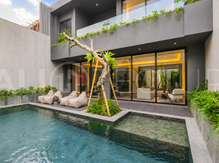 Modern two-storey luxury villa in Ubud featuring a private swimming pool, lush tropical landscaping, floor-to-ceiling glass doors, and a stylish contemporary exterior.
