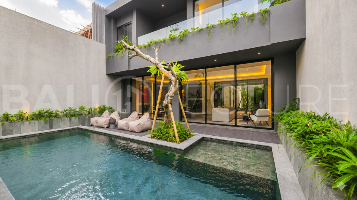 Modern two-storey luxury villa in Ubud featuring a private swimming pool, lush tropical landscaping, floor-to-ceiling glass doors, and a stylish contemporary exterior.