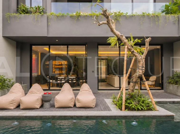 Modern two-storey luxury villa in Ubud featuring a private swimming pool, lush tropical landscaping, floor-to-ceiling glass doors, and a stylish contemporary exterior.