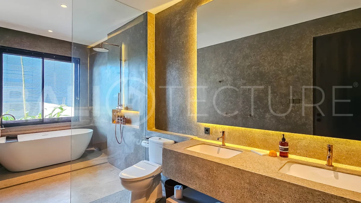 Modern two-storey luxury villa in Ubud featuring a private swimming pool, lush tropical landscaping, floor-to-ceiling glass doors, and a stylish contemporary exterior.