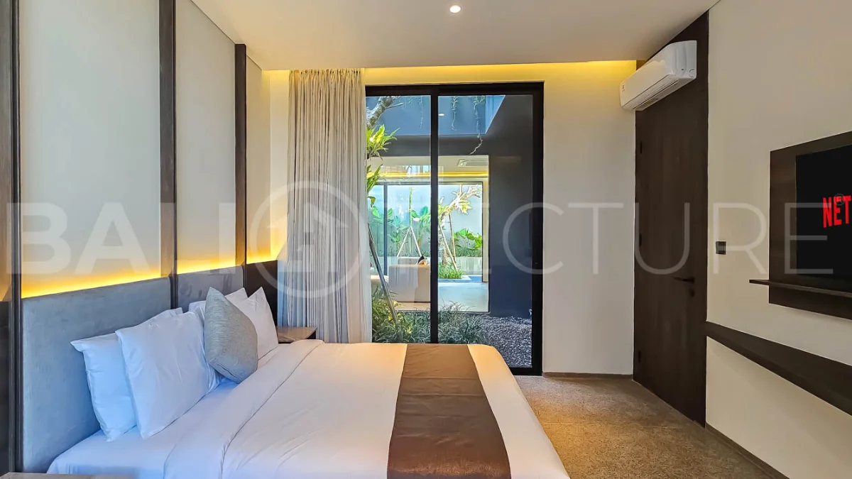 Modern two-storey luxury villa in Ubud featuring a private swimming pool, lush tropical landscaping, floor-to-ceiling glass doors, and a stylish contemporary exterior.