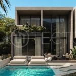 Spacious modern four bedroom villa near Pererenan Beach in Bali, featuring a private swimming pool, tropical landscaping, natural travertine and teak finishes, expansive glazing, elegant interiors, and a landscaped private courtyard.