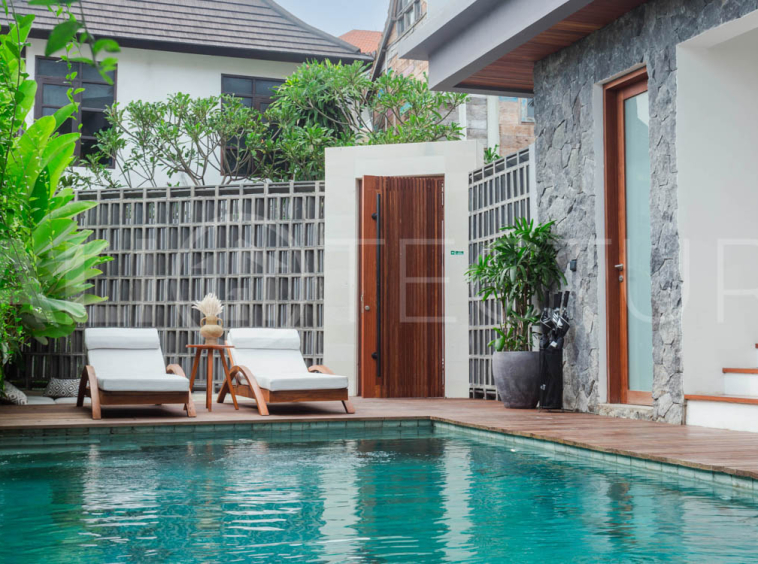 Four-bedroom furnished villa in Padonan, Canggu, featuring three bathrooms, a guest powder room, a private swimming pool, a spacious terrace, a balcony, and flexible indoor-outdoor living spaces, available on a 26-year leasehold.