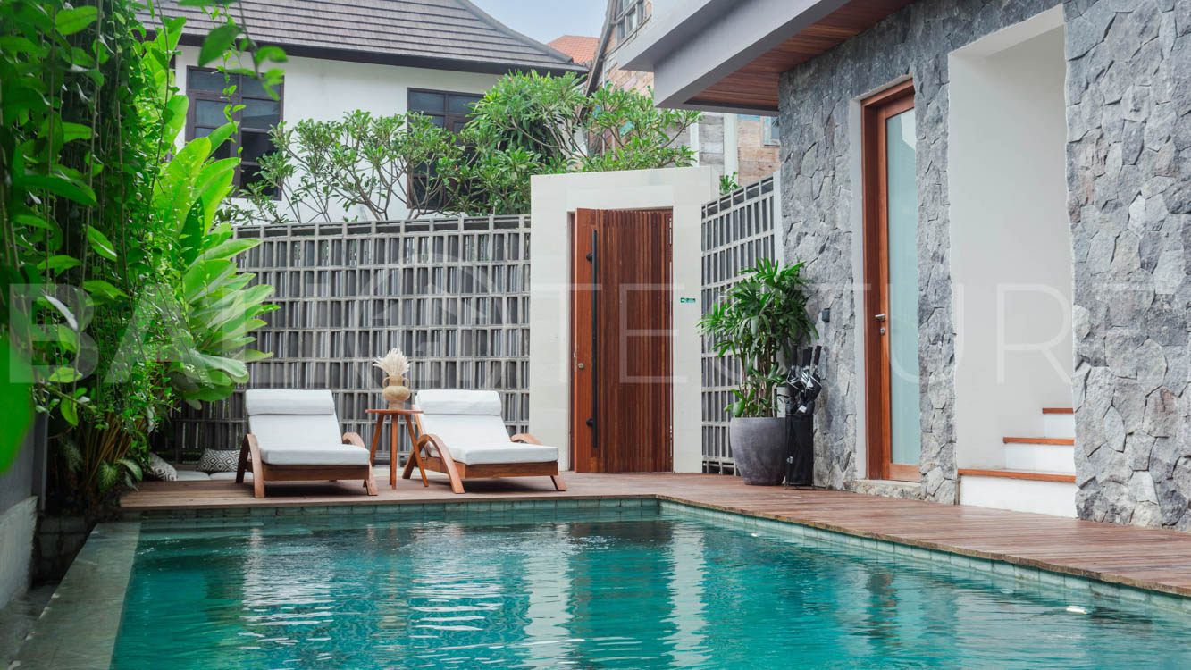 Four-bedroom furnished villa in Padonan, Canggu, featuring three bathrooms, a guest powder room, a private swimming pool, a spacious terrace, a balcony, and flexible indoor-outdoor living spaces, available on a 26-year leasehold.