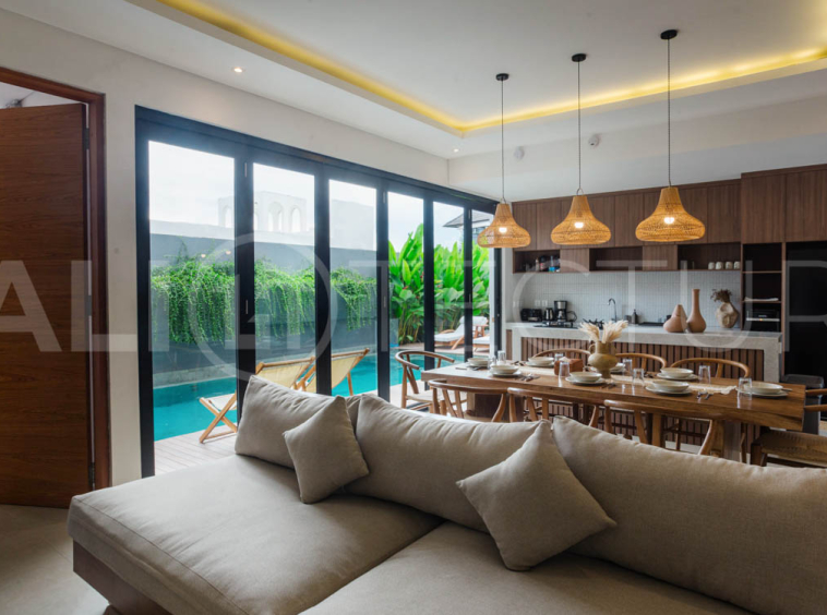 Four-bedroom furnished villa in Padonan, Canggu, featuring three bathrooms, a guest powder room, a private swimming pool, a spacious terrace, a balcony, and flexible indoor-outdoor living spaces, available on a 26-year leasehold.