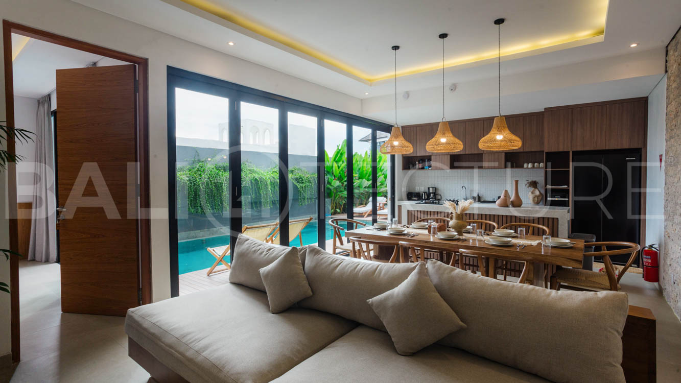 Four-bedroom furnished villa in Padonan, Canggu, featuring three bathrooms, a guest powder room, a private swimming pool, a spacious terrace, a balcony, and flexible indoor-outdoor living spaces, available on a 26-year leasehold.
