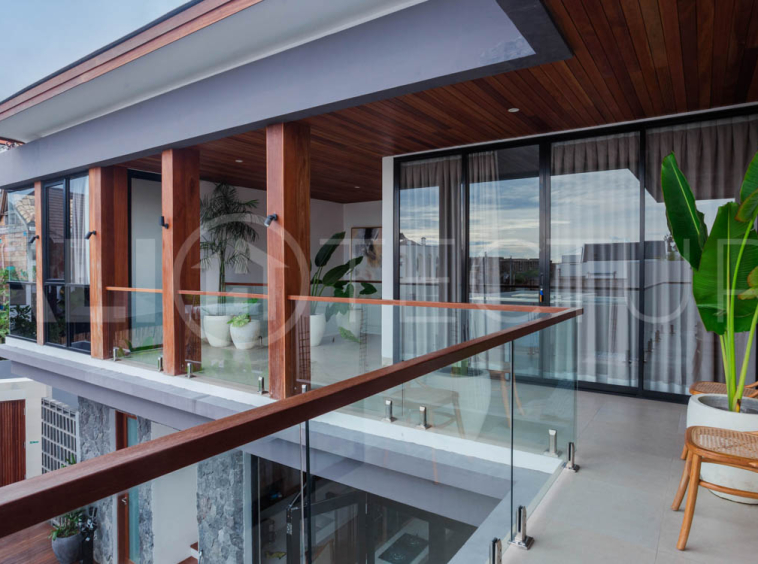 Four-bedroom furnished villa in Padonan, Canggu, featuring three bathrooms, a guest powder room, a private swimming pool, a spacious terrace, a balcony, and flexible indoor-outdoor living spaces, available on a 26-year leasehold.