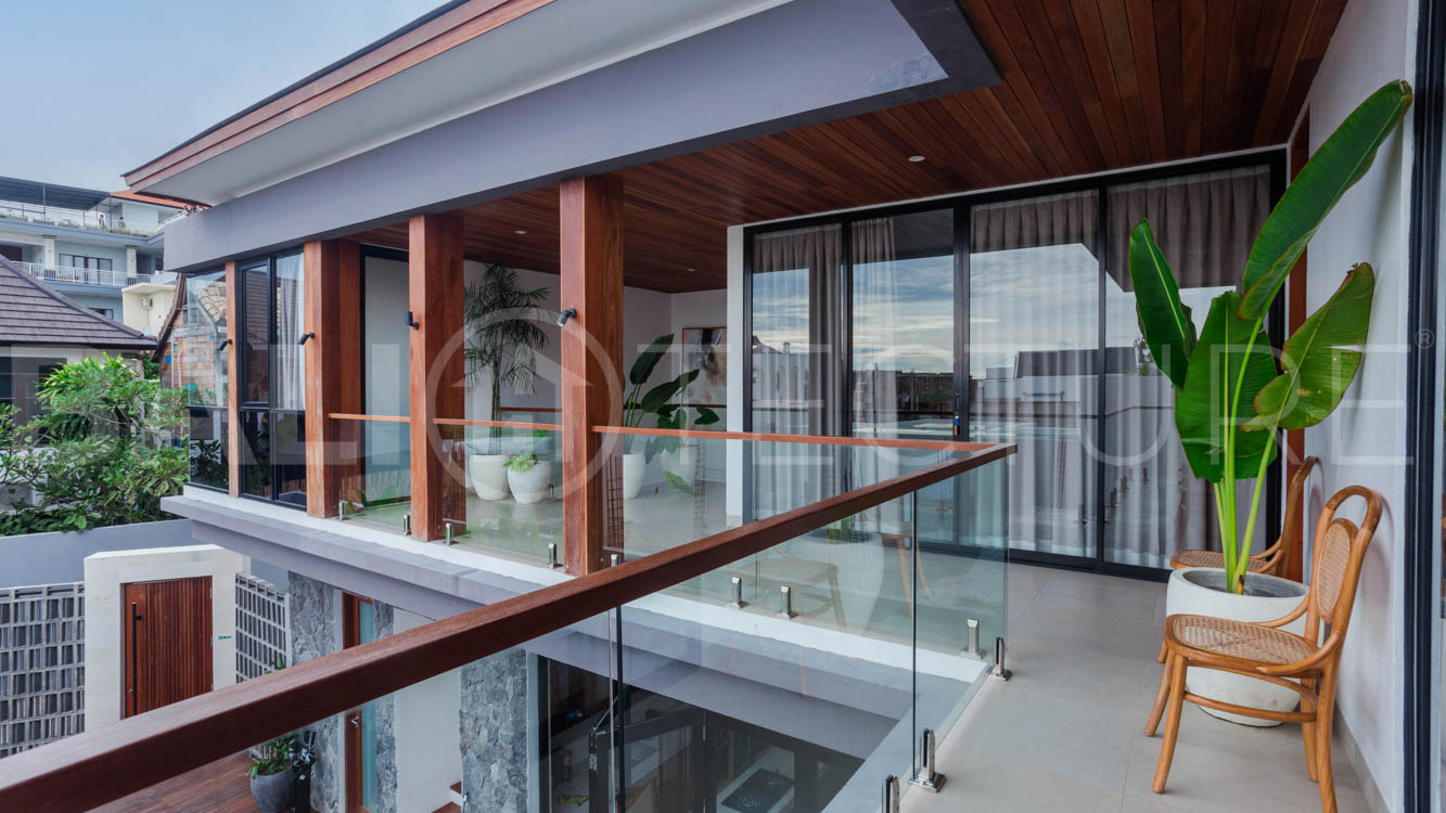 Four-bedroom furnished villa in Padonan, Canggu, featuring three bathrooms, a guest powder room, a private swimming pool, a spacious terrace, a balcony, and flexible indoor-outdoor living spaces, available on a 26-year leasehold.