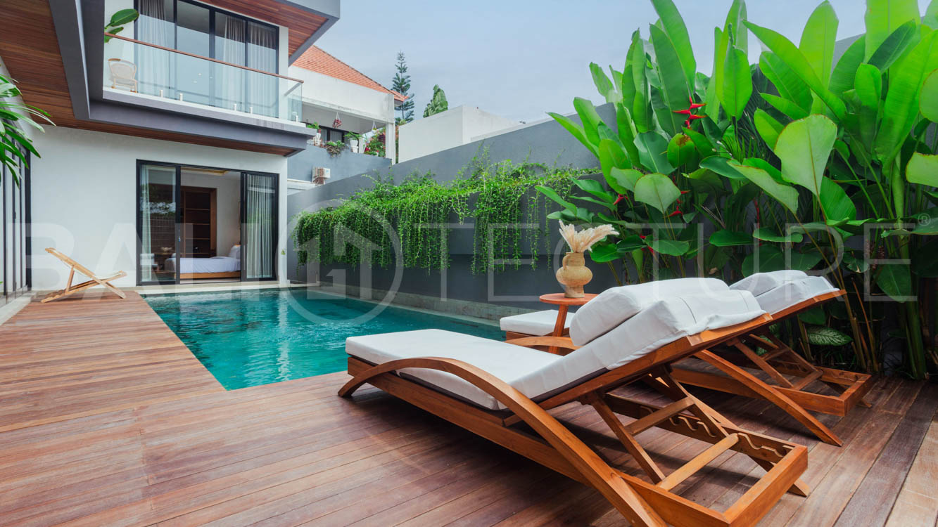 Four-bedroom furnished villa in Padonan, Canggu, featuring three bathrooms, a guest powder room, a private swimming pool, a spacious terrace, a balcony, and flexible indoor-outdoor living spaces, available on a 26-year leasehold.