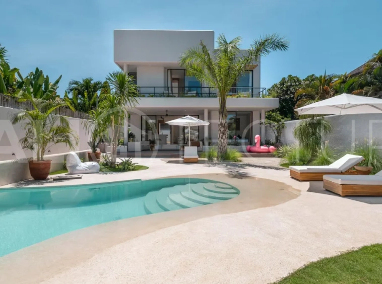 Luxury villa for sale in Canggu, featuring 590.8 m² of land, approximately 200 m² of building space, a lagoon shaped private swimming pool, tropical garden, modern interiors, private sauna, and a leasehold valid until May 2047 with an extension option.