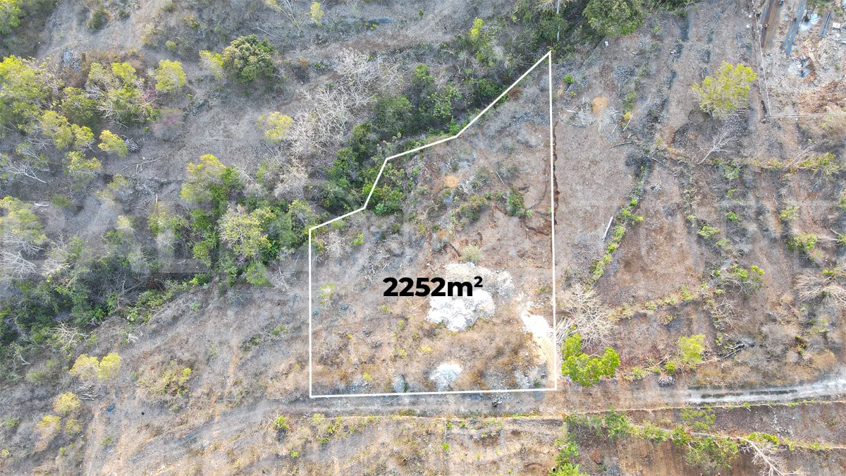 2,252 sqm touristic zoning land for sale in Melasti, South Bali, featuring a sloping landscape with lush jungle surroundings, 4-meter access road, and development potential near Melasti Beach.