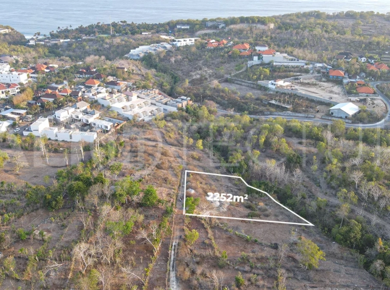 2,252 sqm touristic zoning land for sale in Melasti, South Bali, featuring a sloping landscape with lush jungle surroundings, 4-meter access road, and development potential near Melasti Beach.
