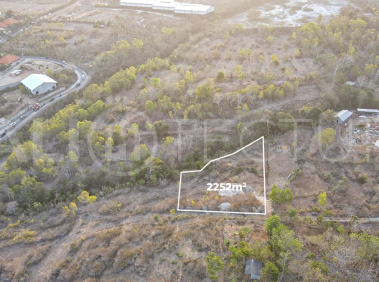 2,252 sqm touristic zoning land for sale in Melasti, South Bali, featuring a sloping landscape with lush jungle surroundings, 4-meter access road, and development potential near Melasti Beach.