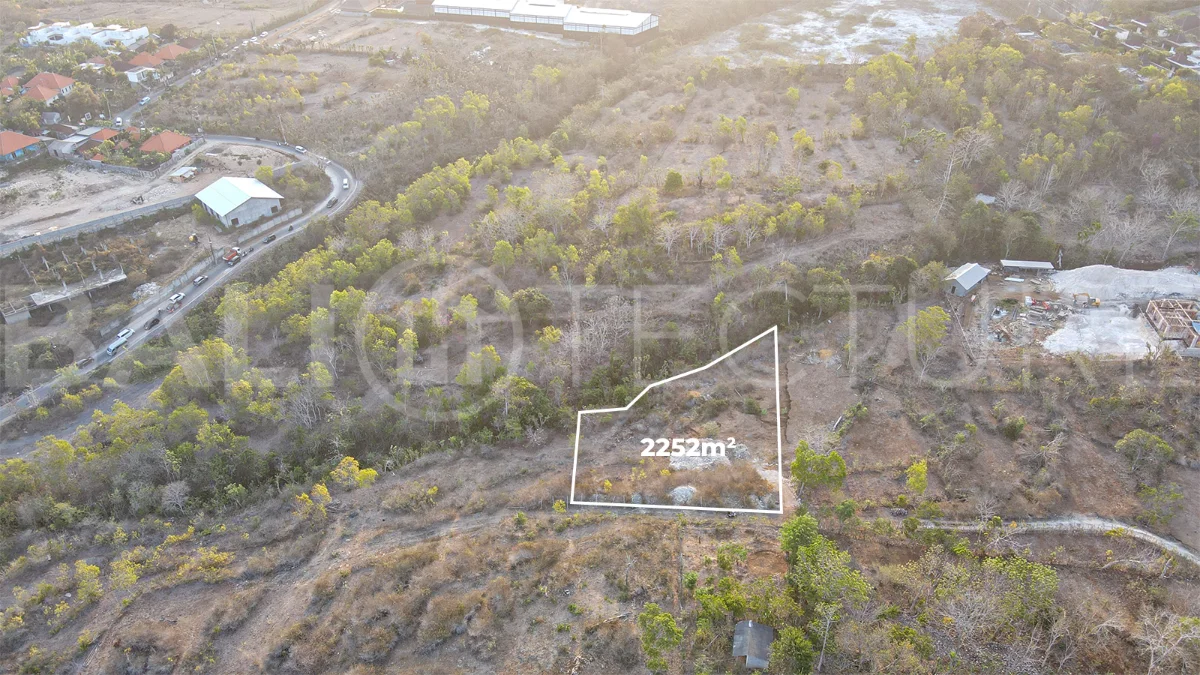 2,252 sqm touristic zoning land for sale in Melasti, South Bali, featuring a sloping landscape with lush jungle surroundings, 4-meter access road, and development potential near Melasti Beach.